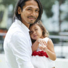 Happy Man and his Daughter Portrait of joyful young man carrying his little daughter in beautiful birthday dress